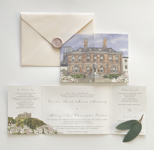 A wedding invitation suite featuring a gatefold invitation with a watercolour illustration of Cashel Palace Hotel, and the Rock of Cashel paired with a blush pink envelope, with a pearlescent pink monogrammed wax seal, displayed on a white background.