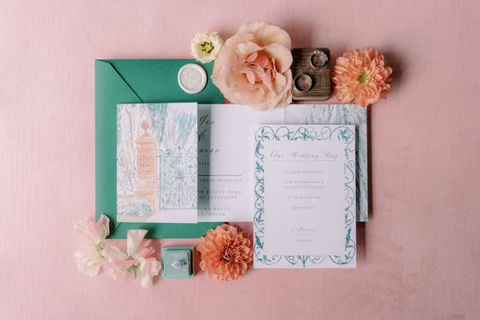 A wedding invitation suite featuring a gatefold invitation with a watercolour illustration of Tankardstown House Walled Garden Gates, and details card with watercolour detailing paired with a forest green envelope, and a pearlescent ivory monogrammed wax seal, displayed on a peach background.